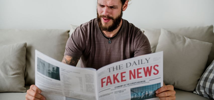 mann myser mot en avis med fake news